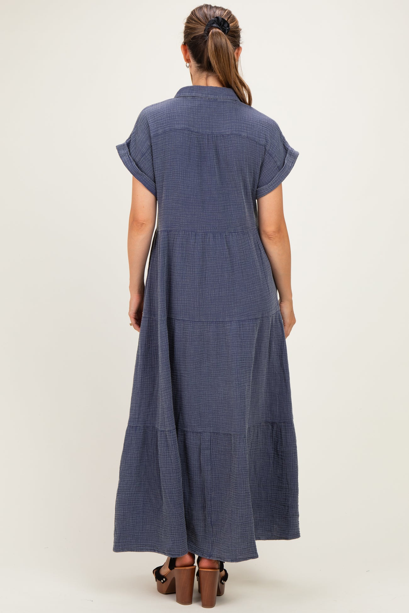 woman wearing a navy blue tiered maxi dress with short sleeves and a collared back view, showing a relaxed fit