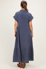 woman wearing a navy blue tiered maxi dress with short sleeves and a collared back view, showing a relaxed fit