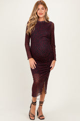 woman wearing a burgundy dotted long sleeve maternity dress with ruching and a side slit, highlighting her baby bump
