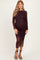 woman wearing a burgundy dotted long sleeve maternity dress with ruching and a side slit, highlighting her baby bump