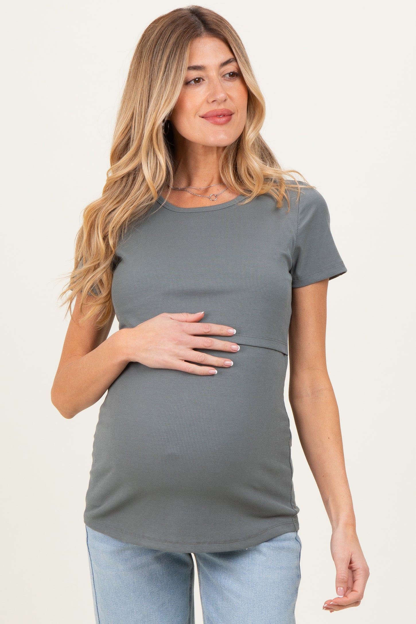 woman wearing a gray short sleeve maternity top and holding her baby bump
