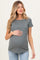 woman wearing a gray short sleeve maternity top and holding her baby bump