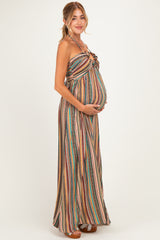 woman wearing a multicolored striped maternity maxi dress and holding her baby bump