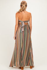 woman wearing a multicolor striped maxi maternity dress with a back tie detail and open back