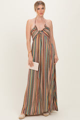 woman wearing a multi-colored striped maxi dress with a halter neckline and holding a small clutch purse