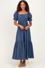 woman wearing a navy blue puff sleeve maxi dress with a square neckline and tiered skirt