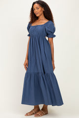 woman wearing a navy blue puff sleeve maxi dress with a square neckline and tiered hem