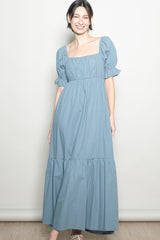 woman wearing a light blue square neck maxi dress with puff sleeves and tiered hem