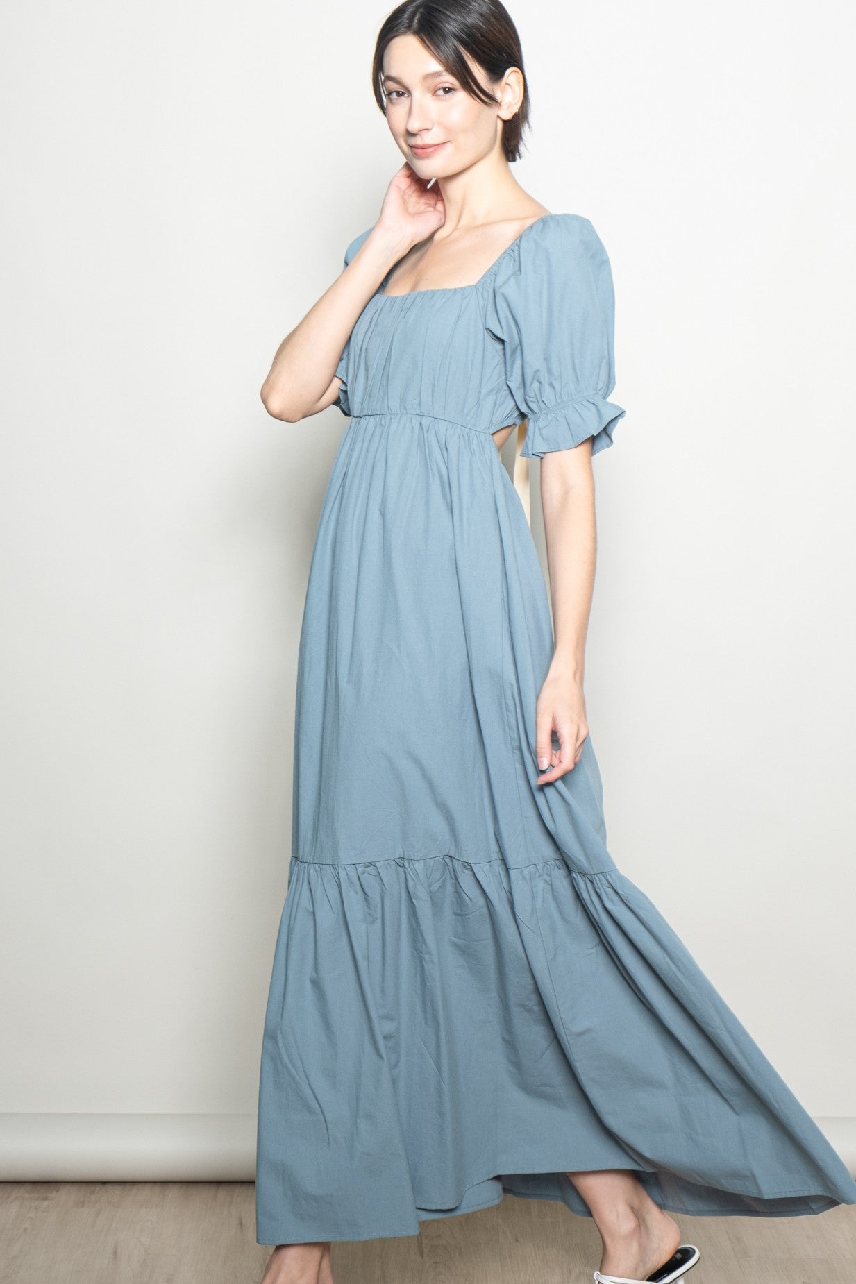woman wearing a light blue maxi dress with puff sleeves and a square neckline
