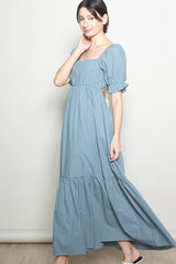 woman wearing a light blue maxi dress with puff sleeves and a square neckline
