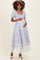 woman wearing a maternity maxi dress with a floral print and lace hemline, holding her baby bump