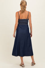 woman wearing a navy blue maternity maxi dress with smocked bodice and adjustable straps, viewed from the back