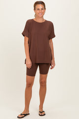 woman wearing a brown oversized t-shirt and matching bike shorts, styled with black flip-flops