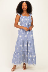 woman wearing a blue and white striped maxi dress with floral print and ruffled straps
