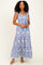 woman wearing a blue and white striped maxi dress with floral print and ruffled straps