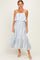 woman wearing a white and blue striped midi dress with ruffled hem and adjustable straps