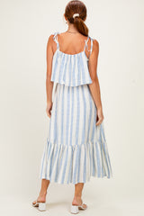 woman wearing a white and blue striped tiered maxi dress with tie straps and a ruffled hemline