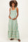 woman wearing a green striped maternity dress with smocked bodice and flowy skirt, holding her baby bump
