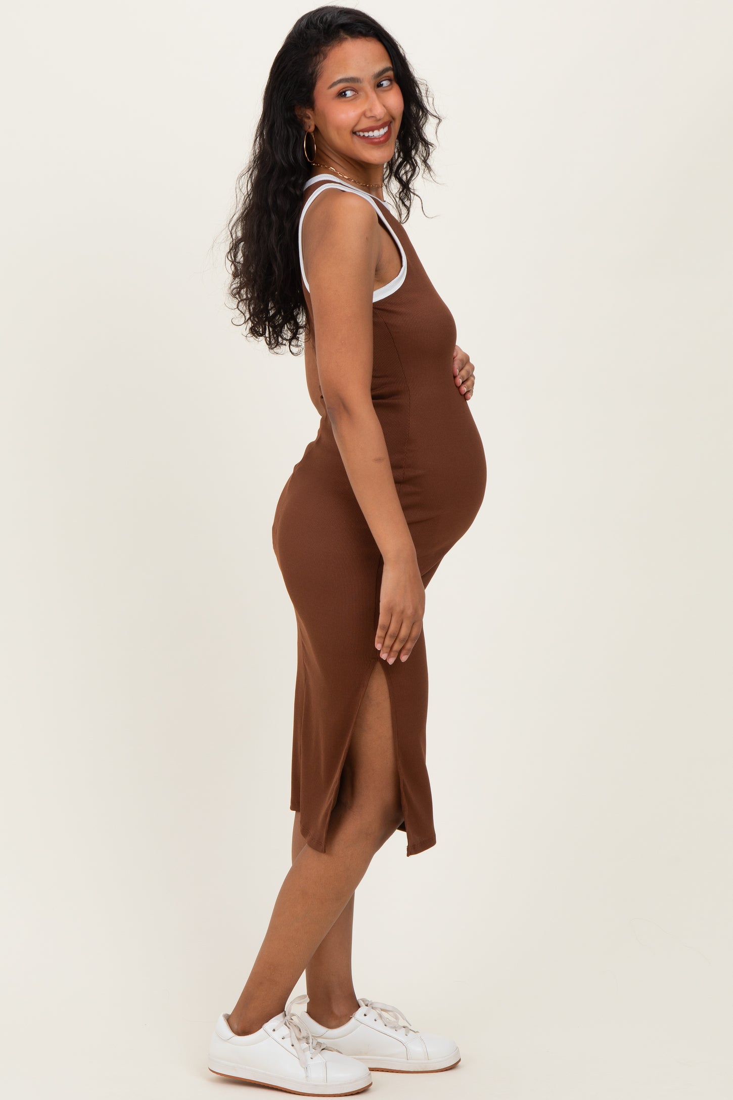 woman wearing a brown ribbed maternity dress with side slits and a baby bump visible