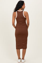 woman wearing a brown maternity dress with white trim, showing a fitted style from the back