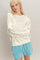 woman wearing a cream floral sweatshirt and blue drawstring shorts