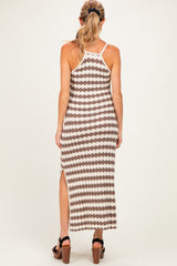 woman wearing a patterned maternity maxi dress with side slit, showing her back and long hair styled in a ponytail