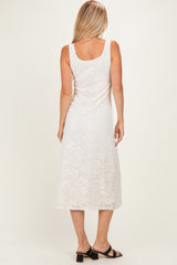 woman wearing a white sleeveless lace midi dress, showing a floral design and back view