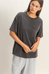 woman wearing an oversized charcoal gray t-shirt with a front pocket and styled with light gray sweatpants