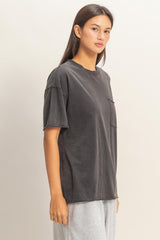 woman wearing a dark gray oversized t-shirt with a pocket and short sleeves
