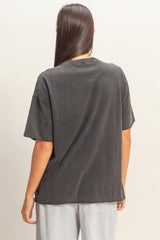 woman wearing a loose-fitting charcoal gray oversized t-shirt with short sleeves