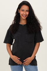 woman wearing a black oversized maternity t-shirt with a front pocket and holding her baby bump