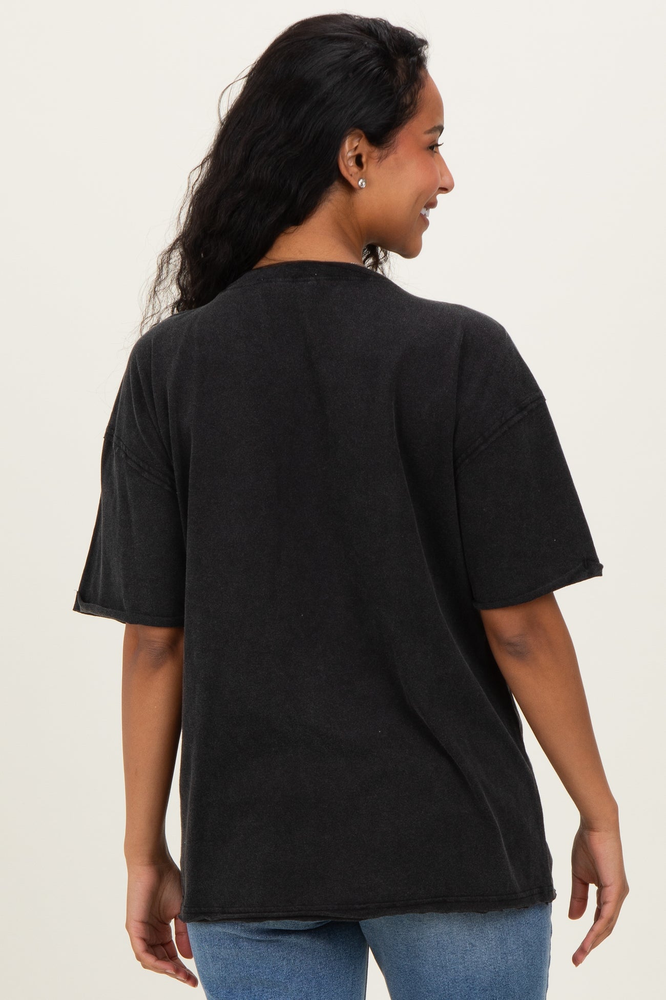 woman wearing a black oversized maternity t-shirt from the back with short sleeves and relaxed fit
