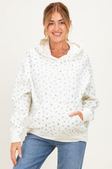 woman wearing a white floral maternity hoodie with a front pocket and relaxed fit