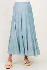 woman wearing a light blue maternity maxi skirt with tiered layers and a comfortable elastic waistband