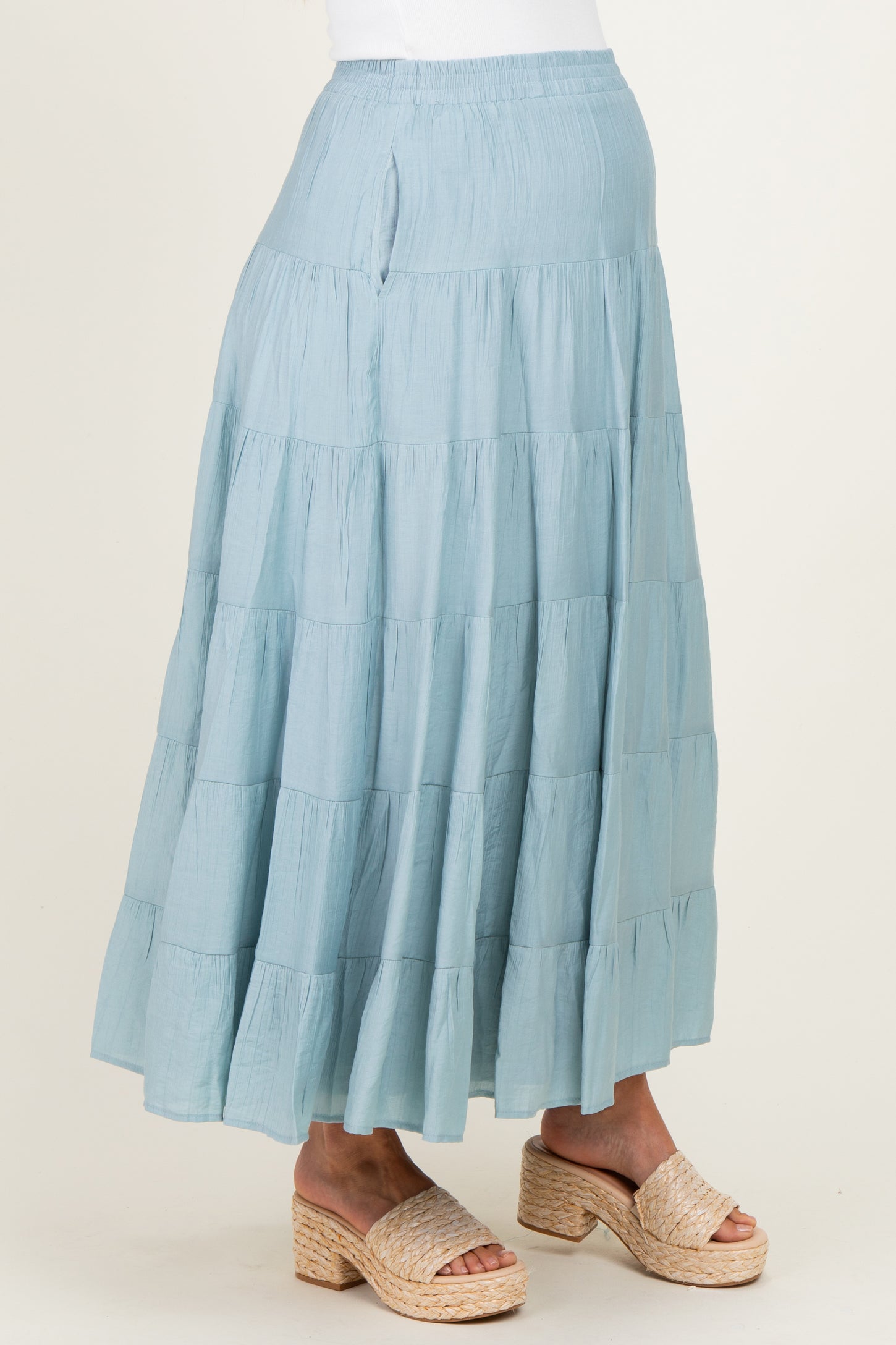 woman wearing a light blue tiered maternity skirt with a flowy design and espadrille wedges