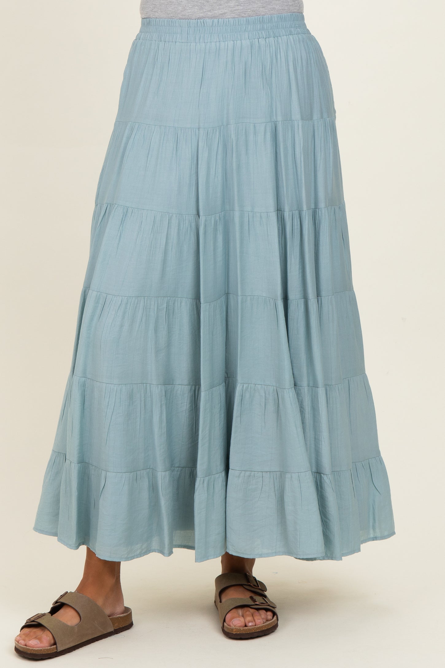 woman wearing a light blue tiered maxi skirt with a flowy design and comfortable sandals