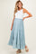 woman wearing a light blue tiered maternity maxi skirt and a white tank top, showing her baby bump