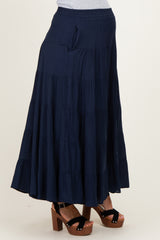 woman wearing a navy blue tiered maternity skirt with pockets and paired with chunky heeled sandals