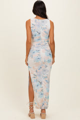woman wearing a sleeveless floral print maxi dress with side slits and ruched detailing, viewed from the back