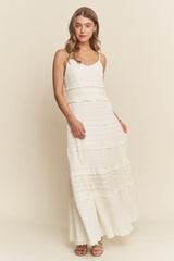 woman wearing a white tiered maxi dress with spaghetti straps and a textured fabric