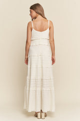 woman wearing a white tiered maxi dress with spaghetti straps and a textured fabric, shown from the back