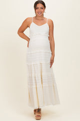 woman wearing a white tiered maternity maxi dress with adjustable straps and a visible baby bump