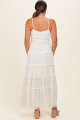 woman wearing a white maternity maxi dress with tiered ruffles and adjustable spaghetti straps, showing a baby bump