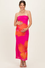 woman wearing a pink strapless maternity dress with large floral print and holding her baby bump