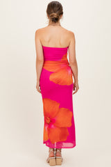 woman wearing a pink strapless maternity dress with large orange floral print, showing baby bump from the back