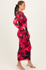 woman wearing a long sleeve red and black floral print dress with a fitted silhouette and a black ribbon in her hair