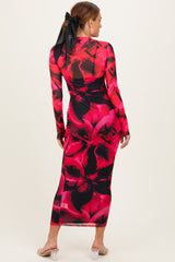 woman wearing a long sleeve pink and black floral print maxi dress with a back bow detail