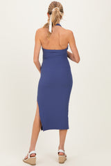 woman wearing a navy blue ribbed maternity dress with a halter neck and side slits
