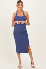woman wearing a navy blue ribbed maternity halter dress with a side slit and a baby bump visible
