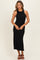 woman wearing a black ribbed knit sleeveless midi dress with side slits and a fitted silhouette